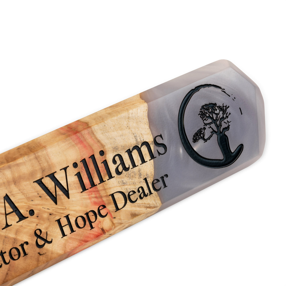 Close-up of a name, title and tree logo engraved in black on platinum epoxy and maple burl