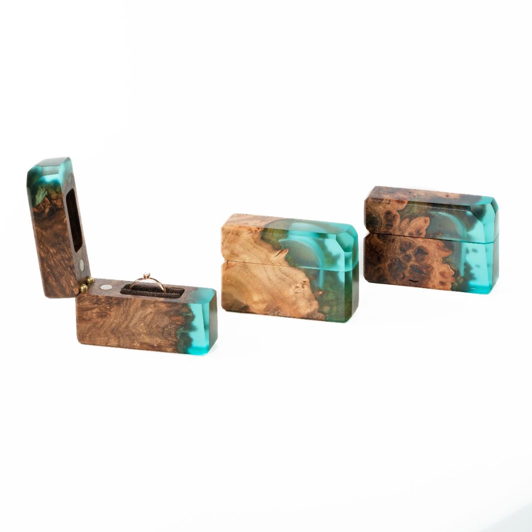 Compact set of aqua blue epoxy and maple wood engagement ring boxes displayed from multiple angles
