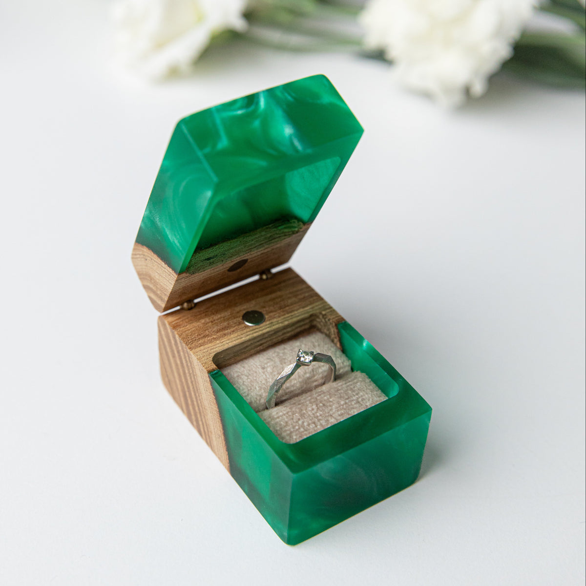 Open green CHORD proposal ring box holding a solitaire ring in a soft pillow