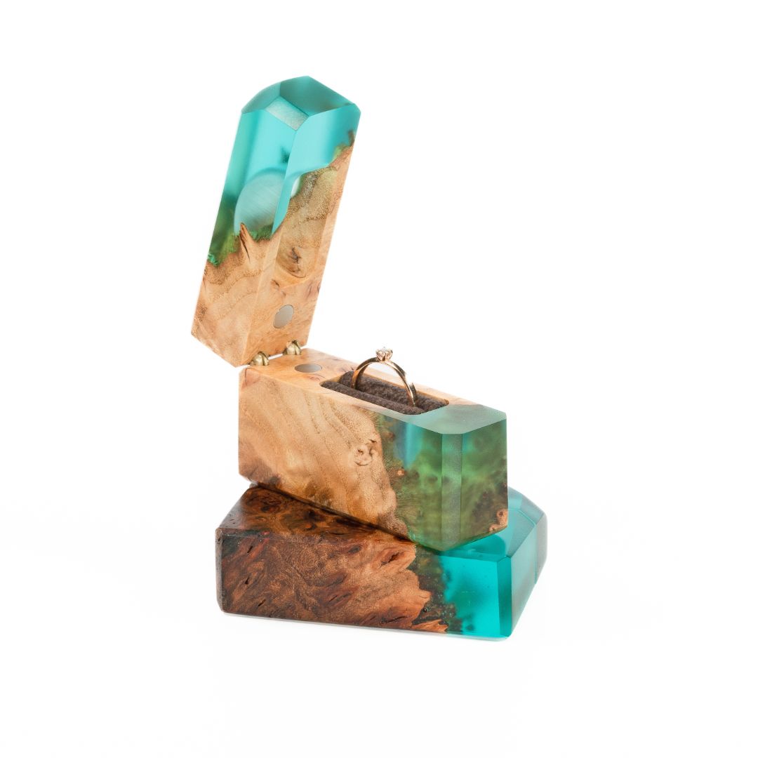 Elegant open aqua blue epoxy and maple wood engagement ring box with the ring compartment visible
