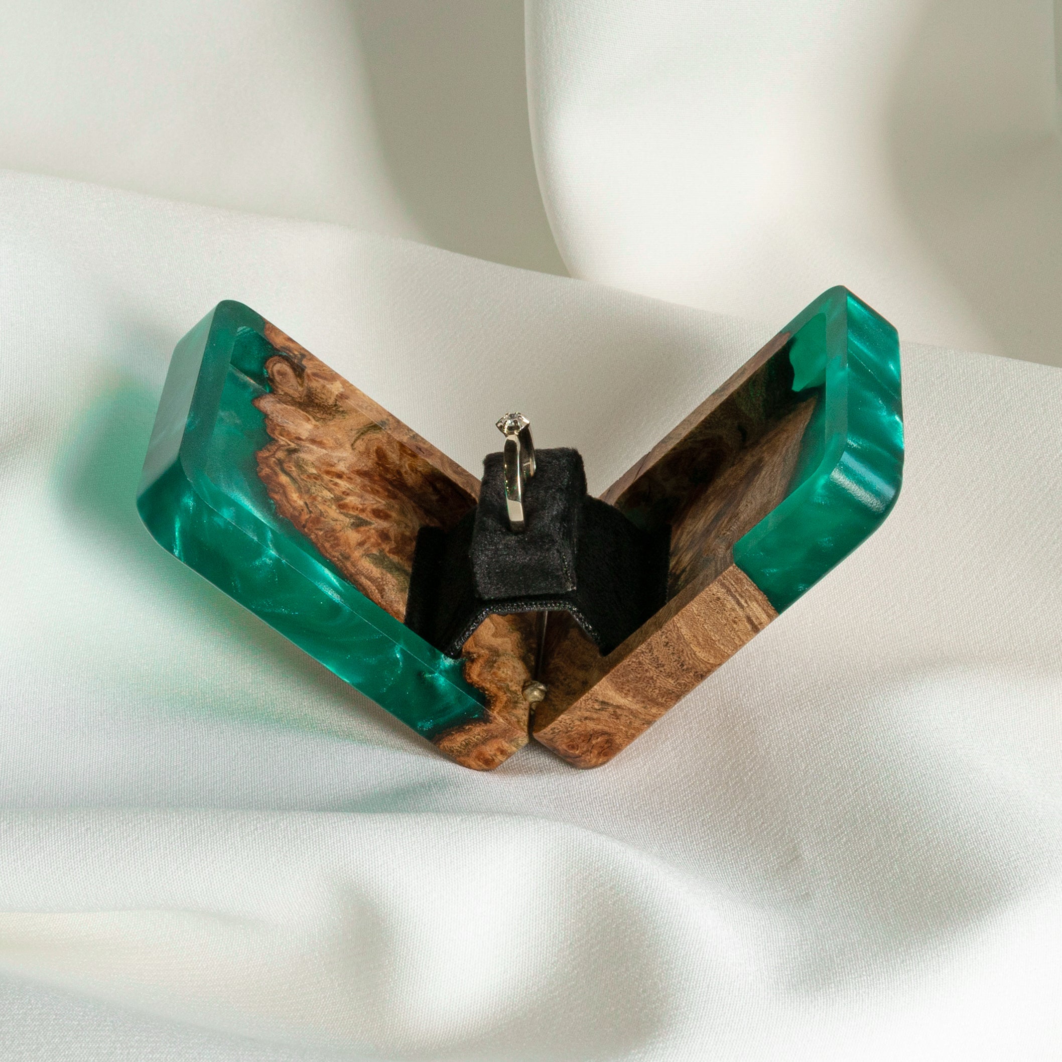Top view of the open green epoxy and elm wood engagement ring box with black ring holder