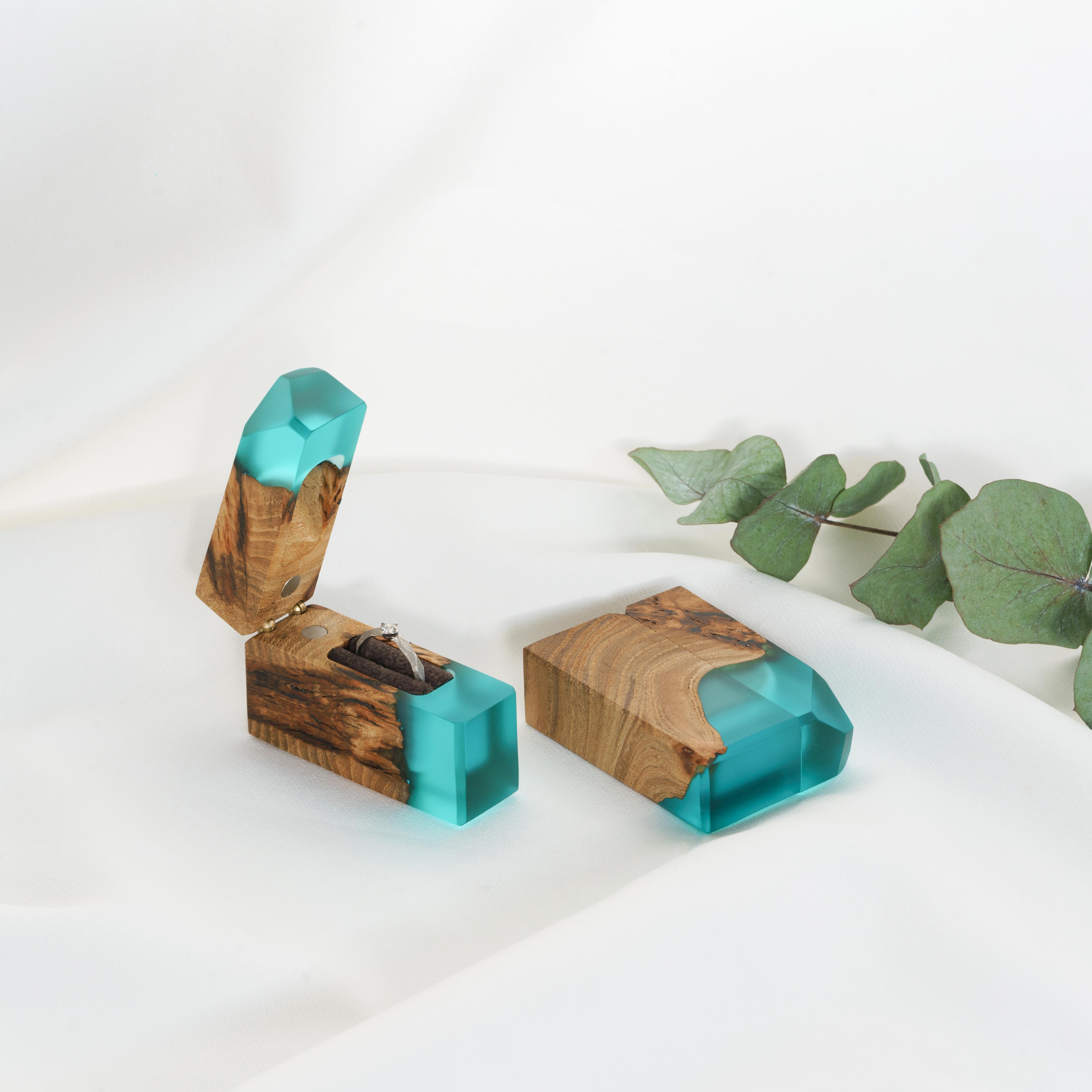 Luxury aqua blue epoxy and maple wood engagement ring box displayed with eucalyptus leaves