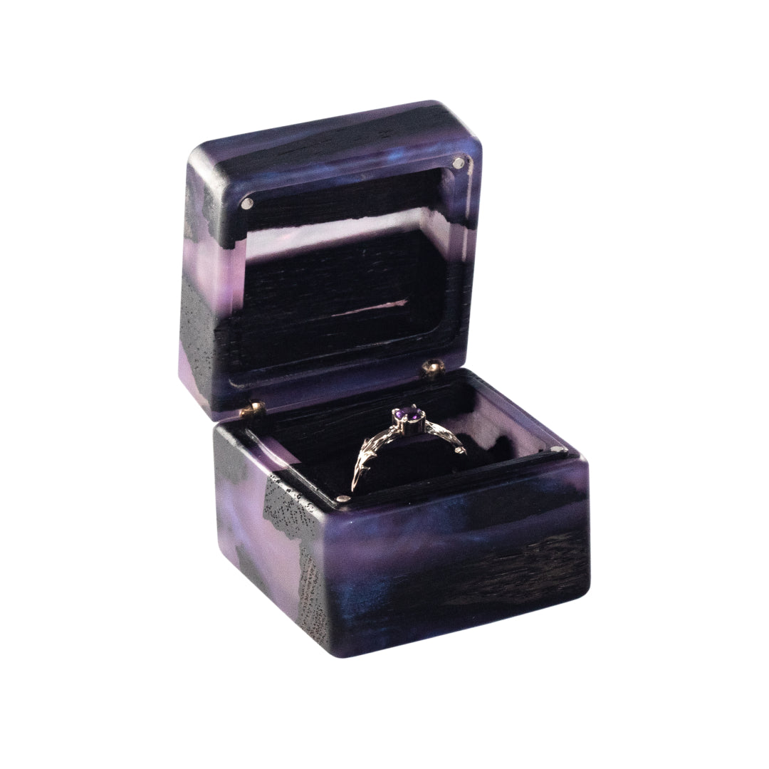 Minimalist open purple epoxy and bog oak wood proposal ring box photographed on a white background