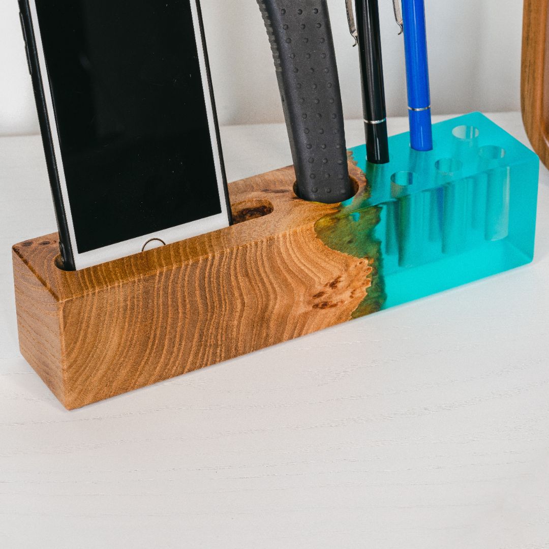 Front view of the ELEMENT office desk organizer with phone stand and pen holder made from elm wood and aqua blue epoxy resin