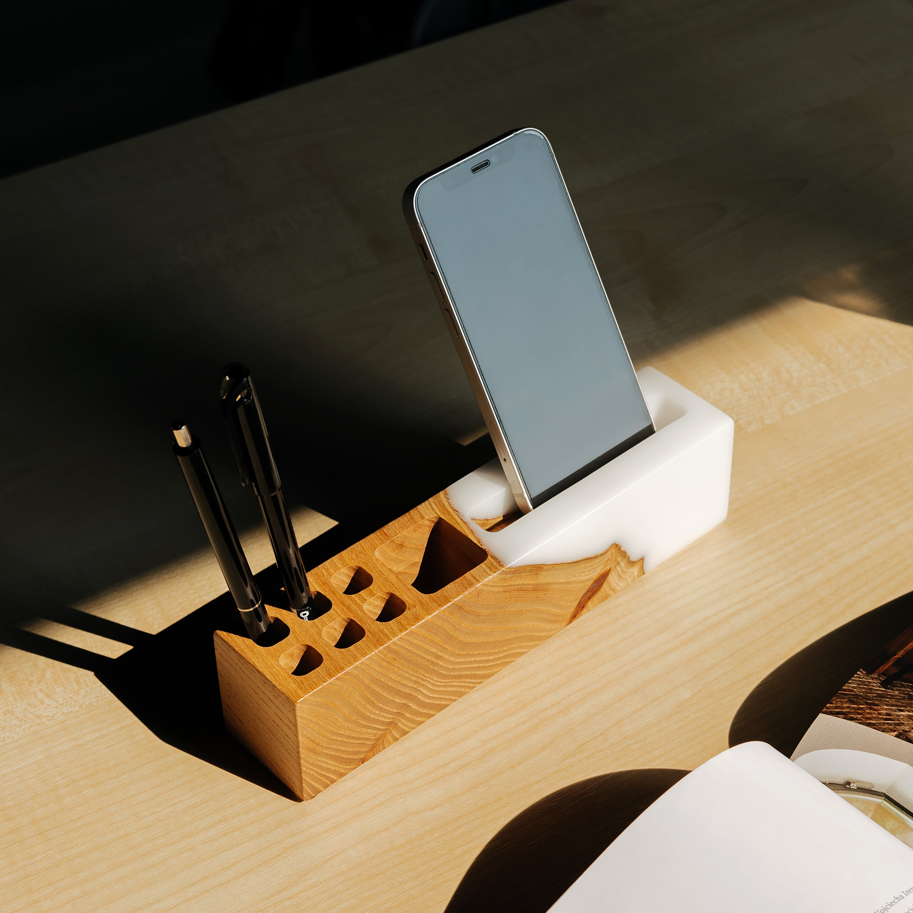 Angled view of the ELEMENT office desk organizer handcrafted from elm wood and white epoxy resin