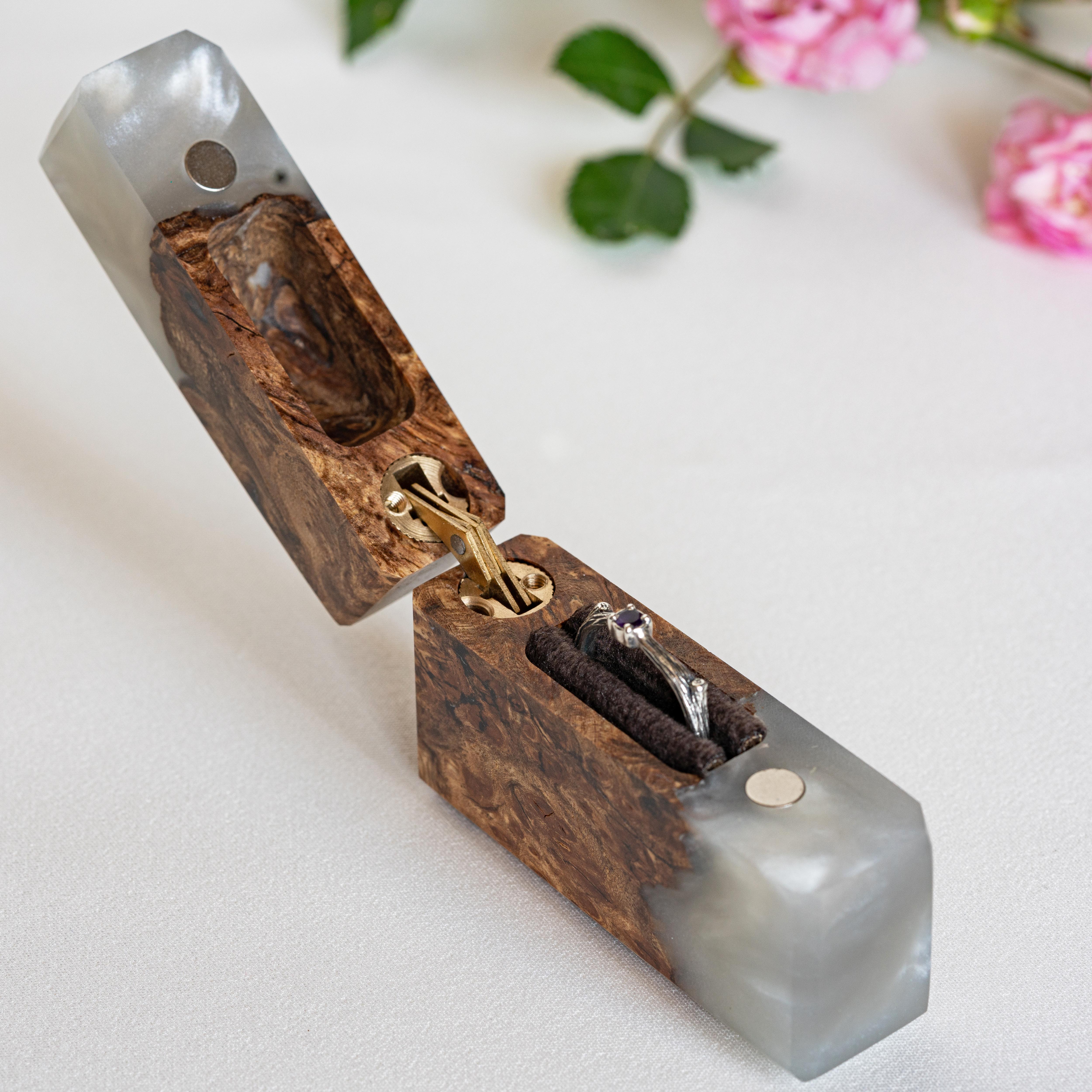 Side profile of the open platinum epoxy and elm wood engagement ring box with the ring holder visible