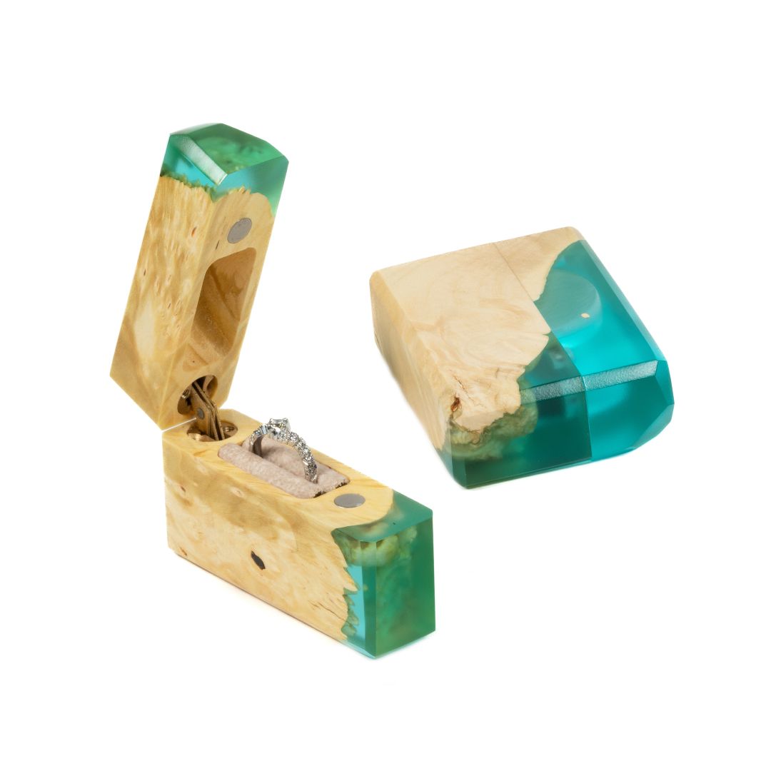 Handcrafted aqua blue epoxy and maple wood proposal ring box photographed from a front angle