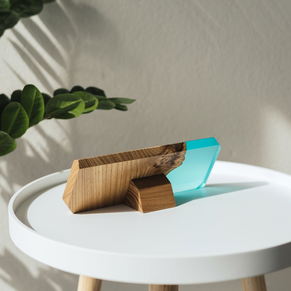 Back of the custom MODERN name plate: elm support foot and aqua blue epoxy end on a white side table