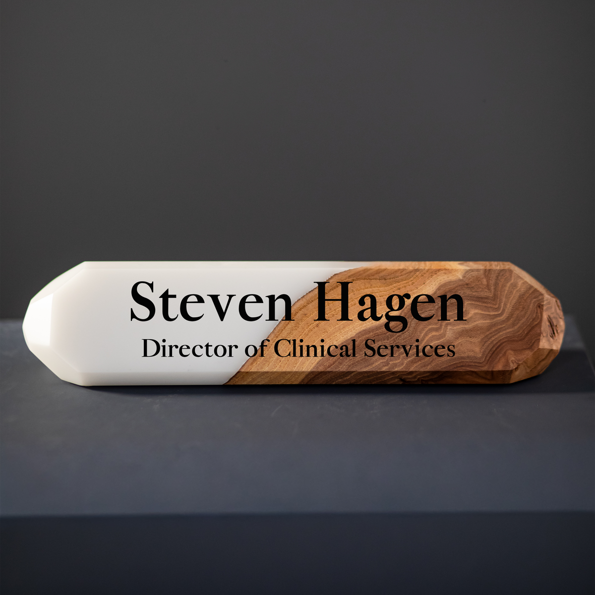 Front view of the faceted white epoxy and elm name plate with a black engraved name and job title