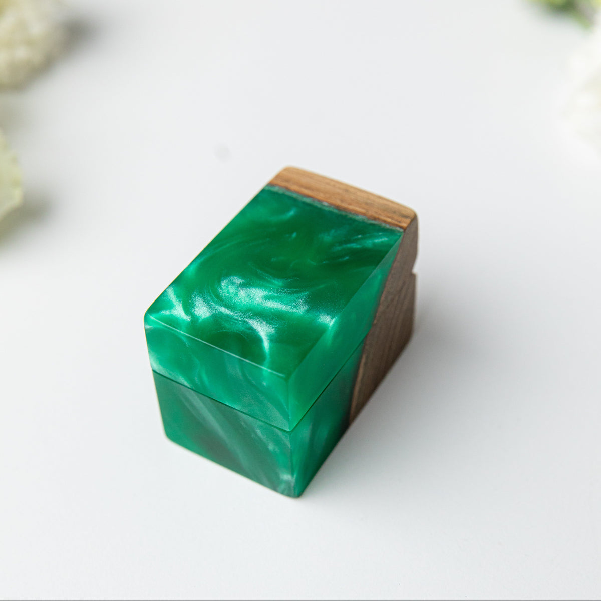 Closed green epoxy ring box with pearly swirls and a strip of elm wood along the edge