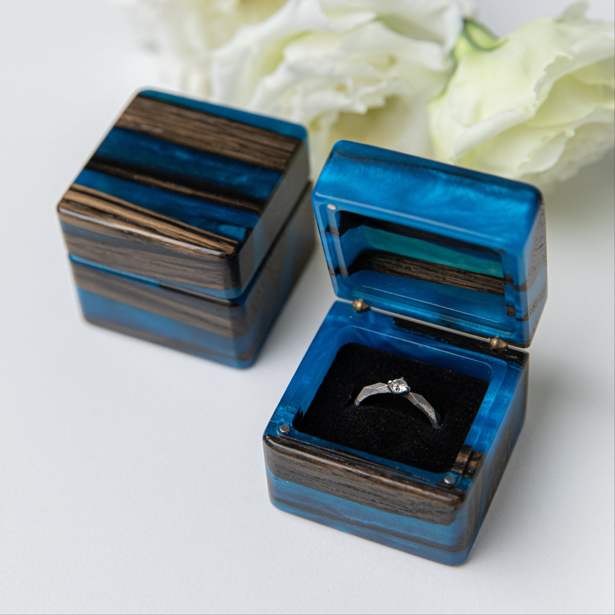 Blue epoxy and bog oak engagement ring box shown closed and open with a solitaire ring