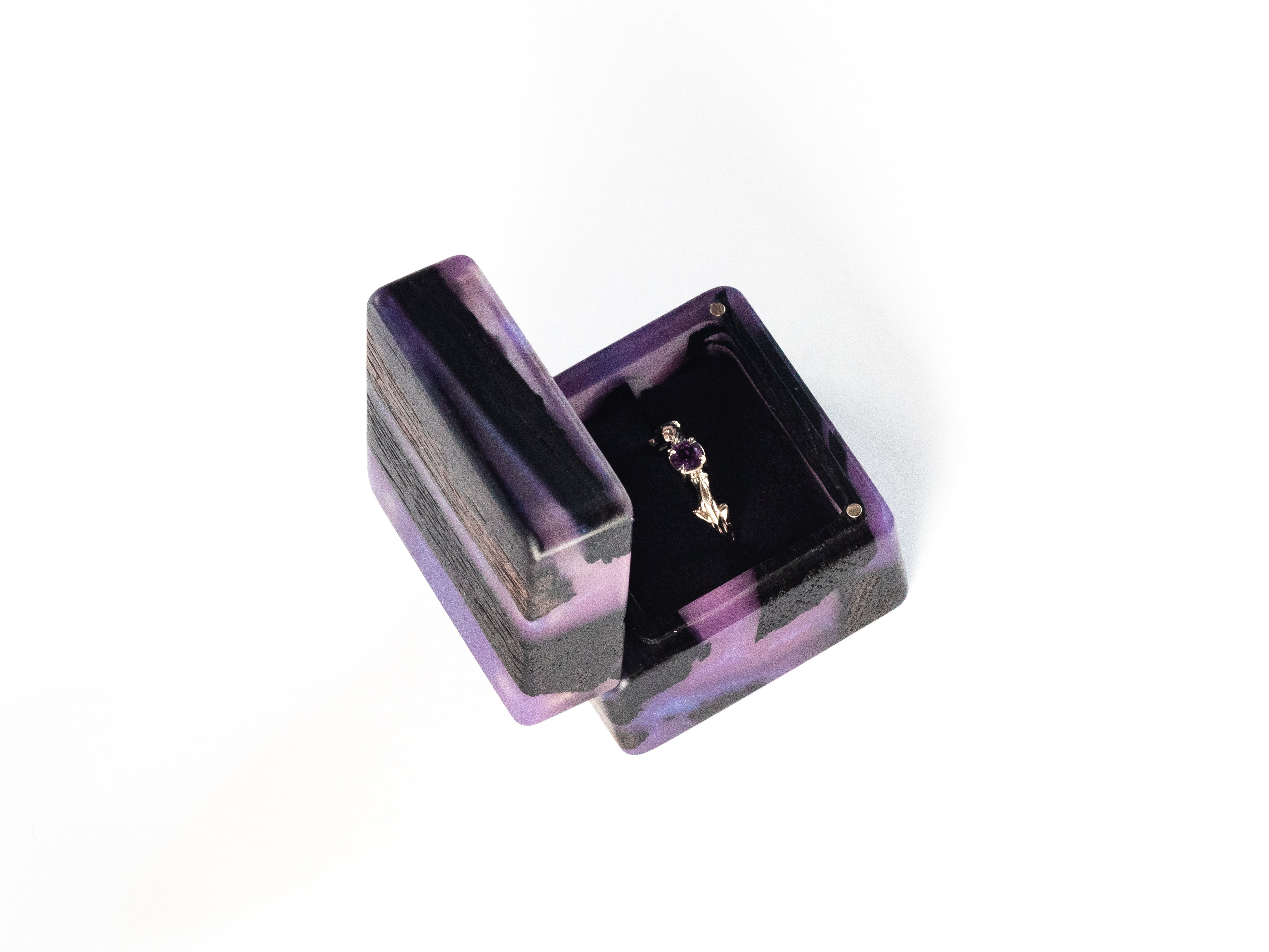 Minimalist open purple epoxy and bog oak wood proposal ring box photographed on a white background