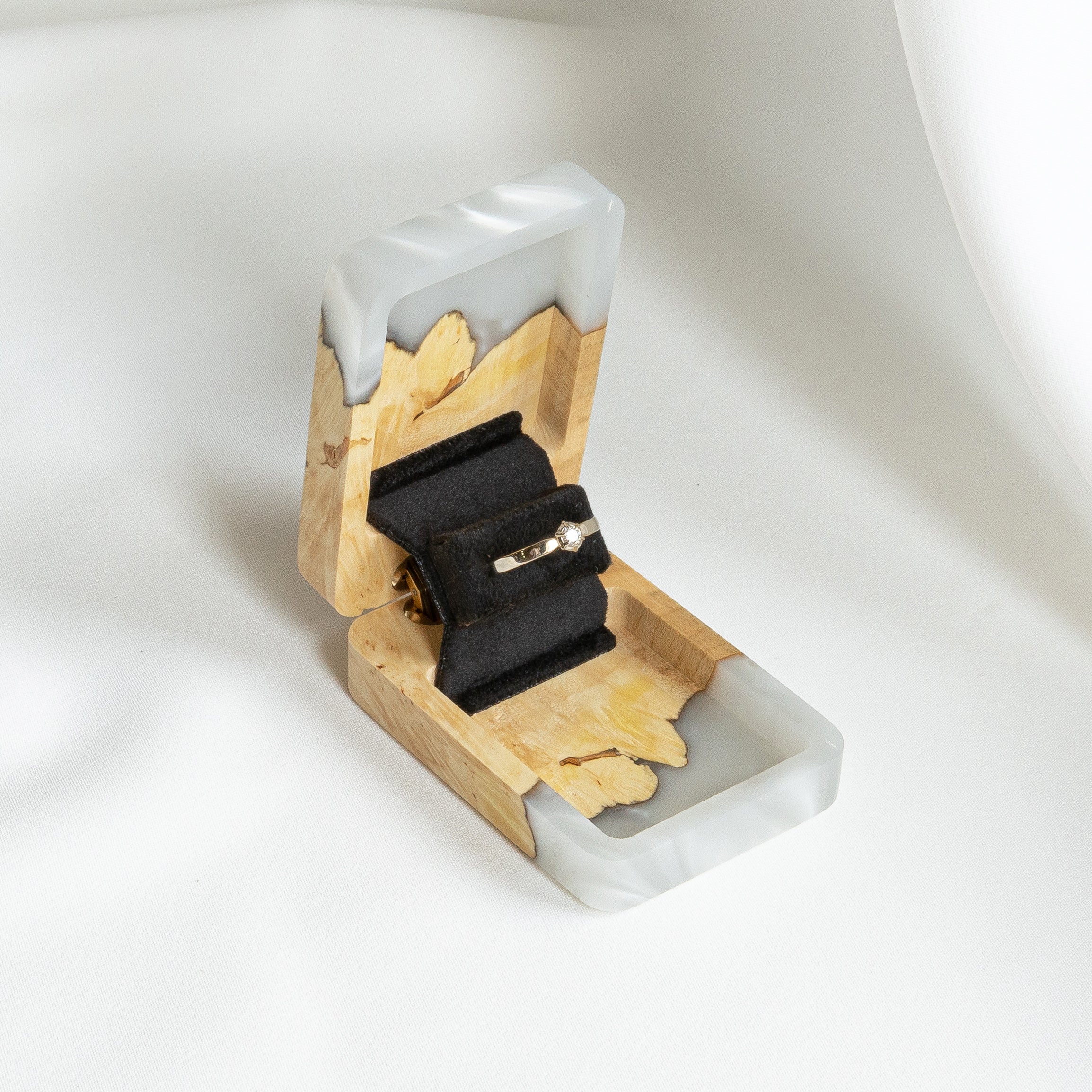Luxury platinum epoxy and maple wood engagement ring box displayed open on a white background