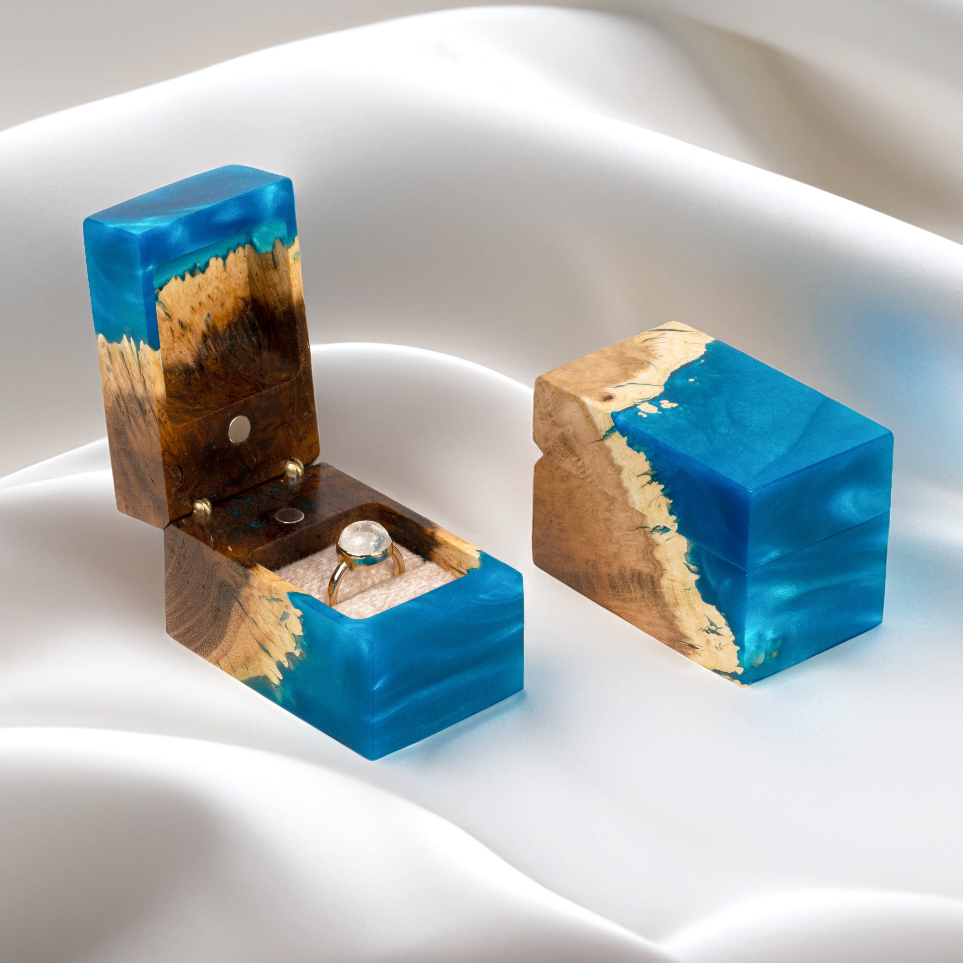 Open engagement ring box handcrafted from blue epoxy and elm wood with the matching closed box beside it
