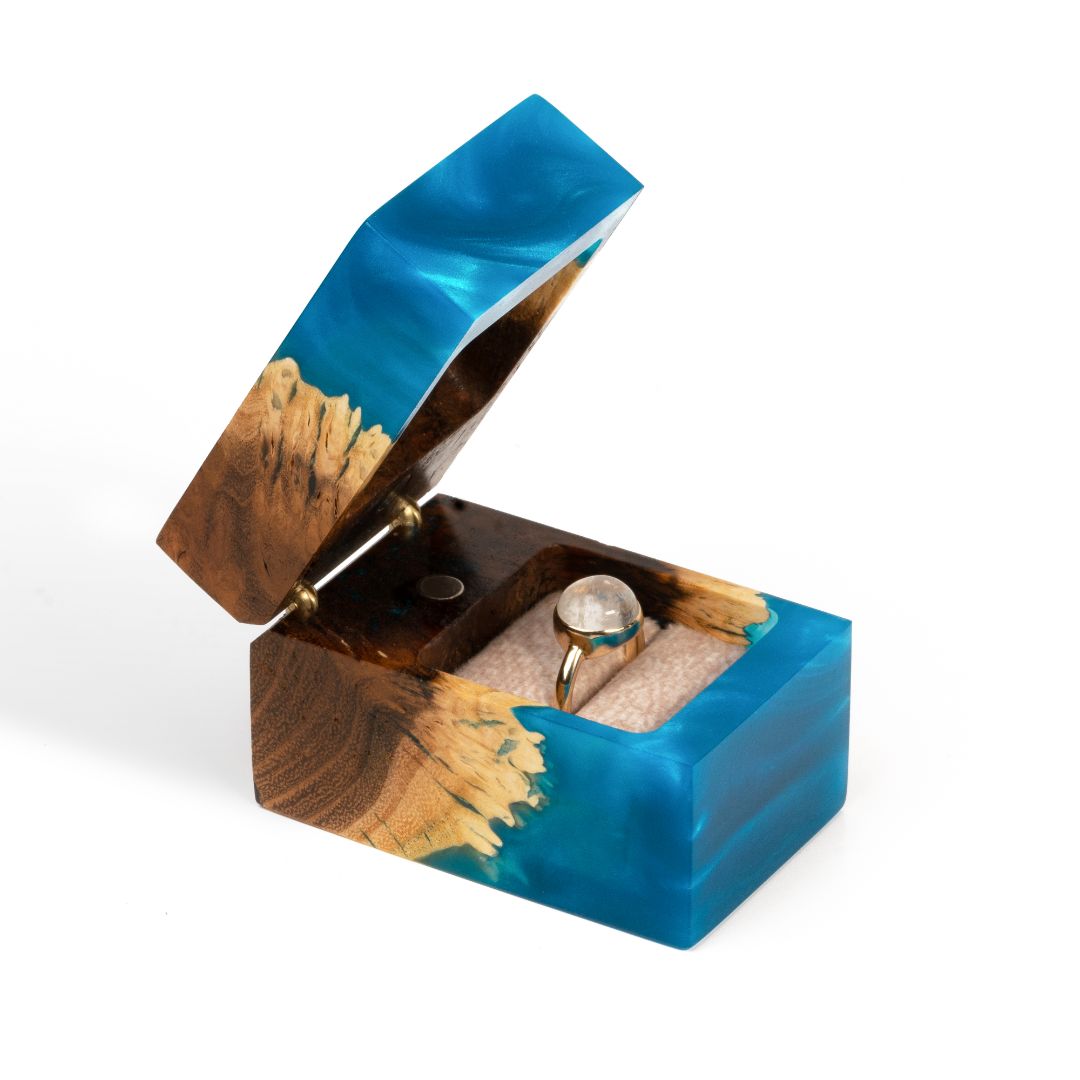 Elegant open blue epoxy and elm wood engagement ring box with the ring compartment visible