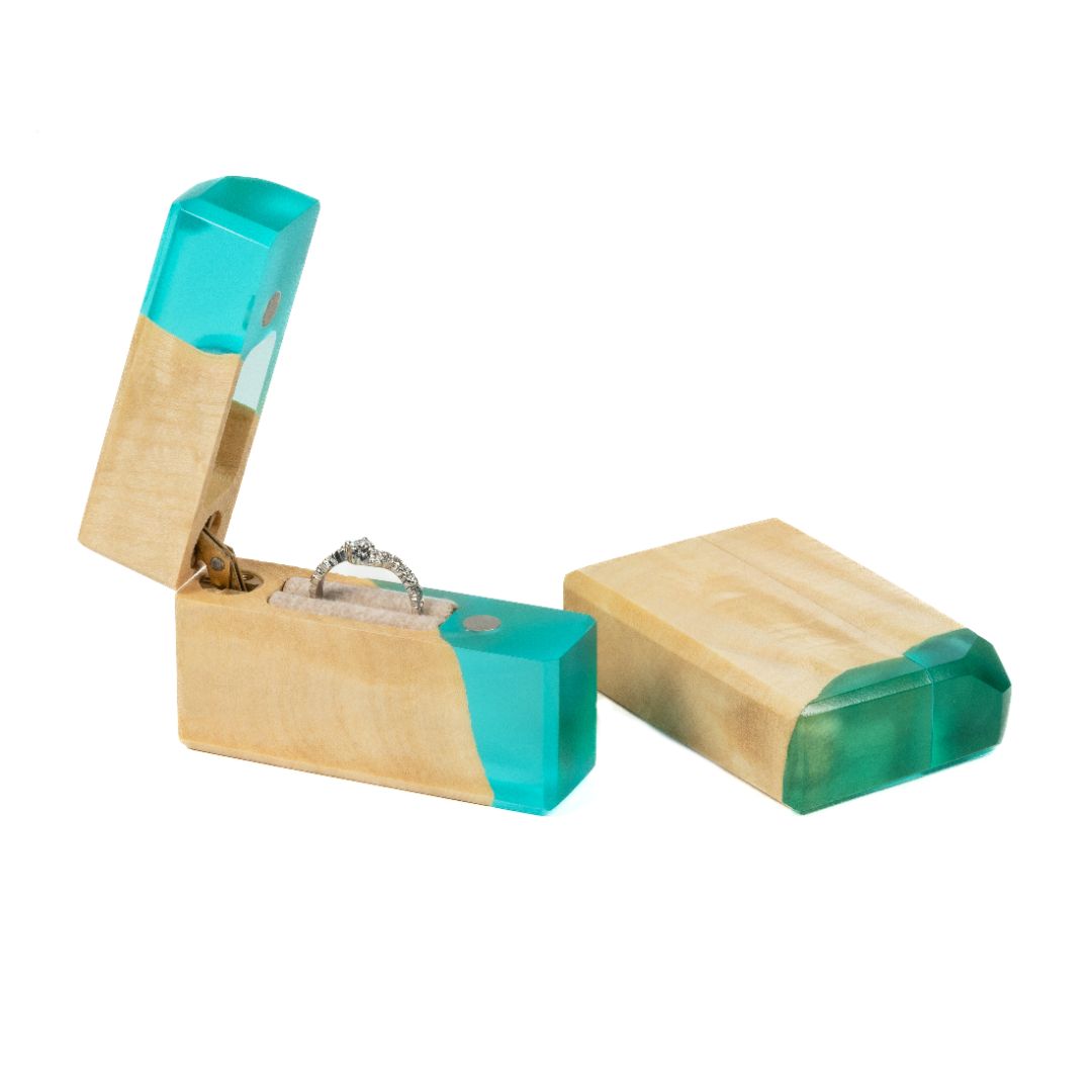 Elegant open aqua blue epoxy and maple wood proposal ring box displayed on a white background