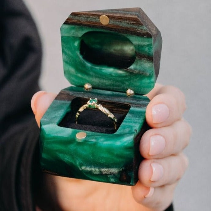 Green epoxy and bog oak wood engagement ring box held in hand to show its size and craftsmanship