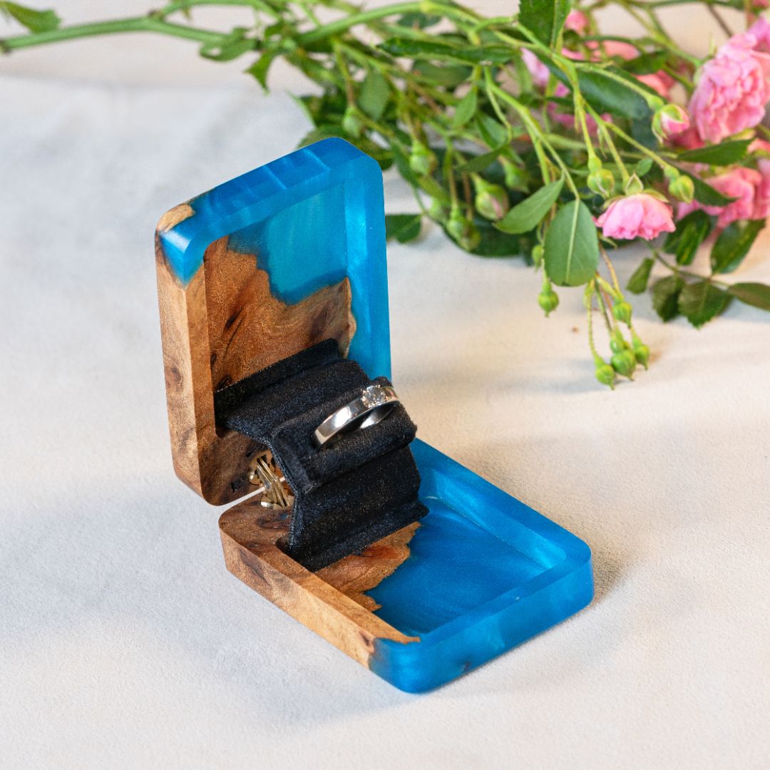 Luxury blue epoxy and elm wood proposal ring box displayed open with floral accents