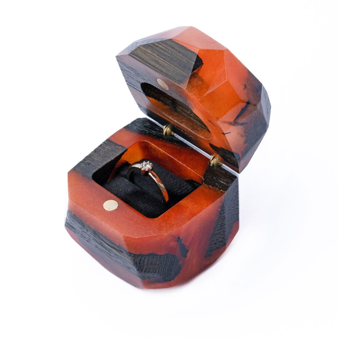 Premium open amber epoxy and bog oak wood proposal ring box photographed from a three-quarter angle
